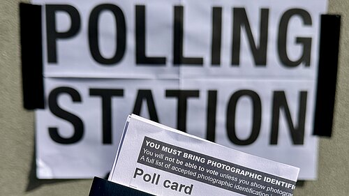 Polling station sign with poll card and passport